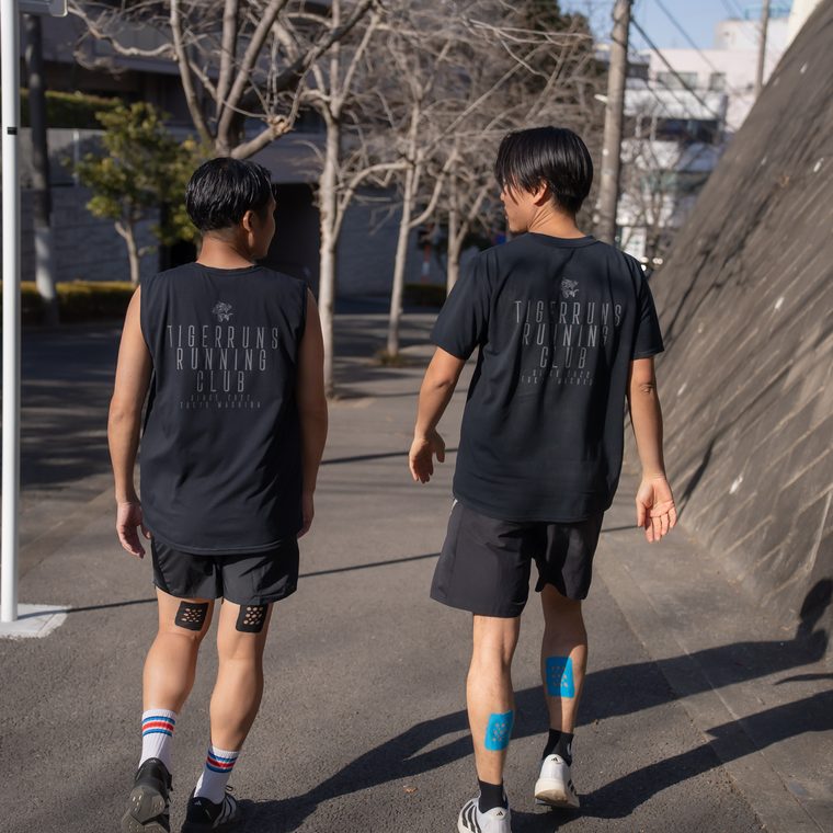 ランニング後に歩いてクールダウンするランナーの後ろ姿