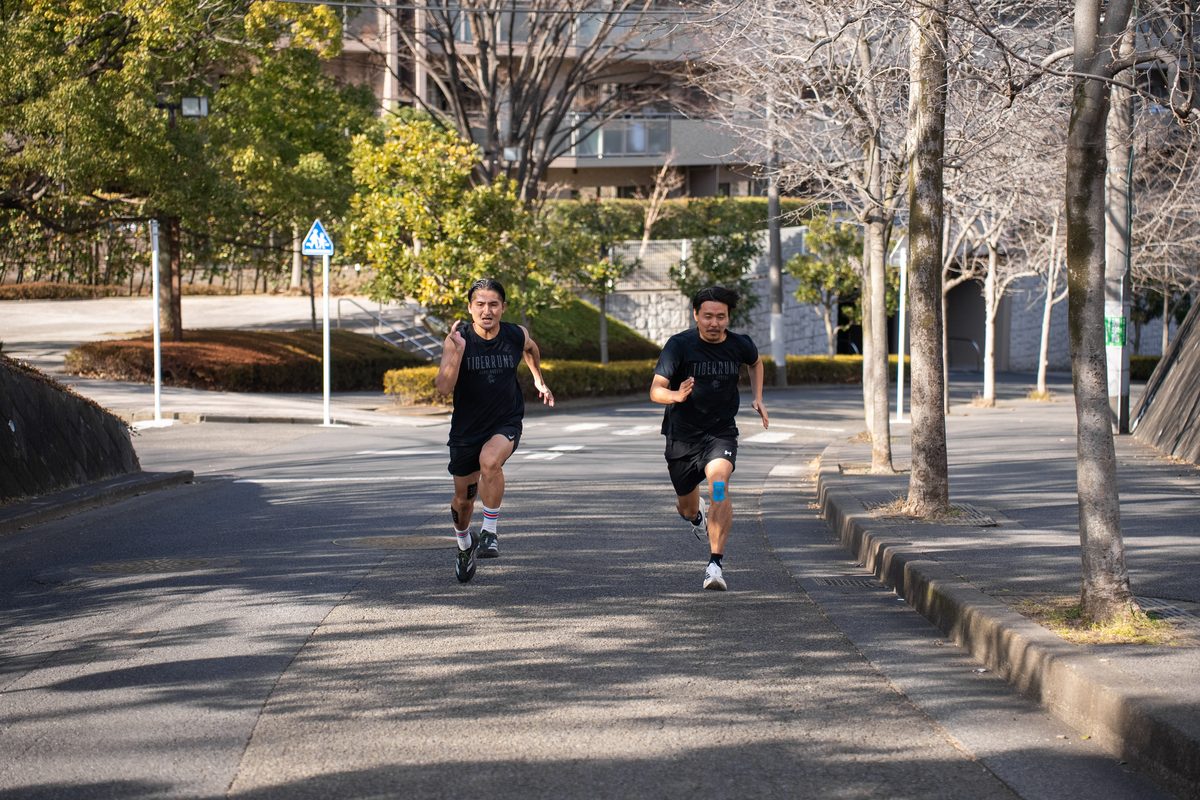 街路をこちらへ向かって走る TIGERRUNS のランナー2人