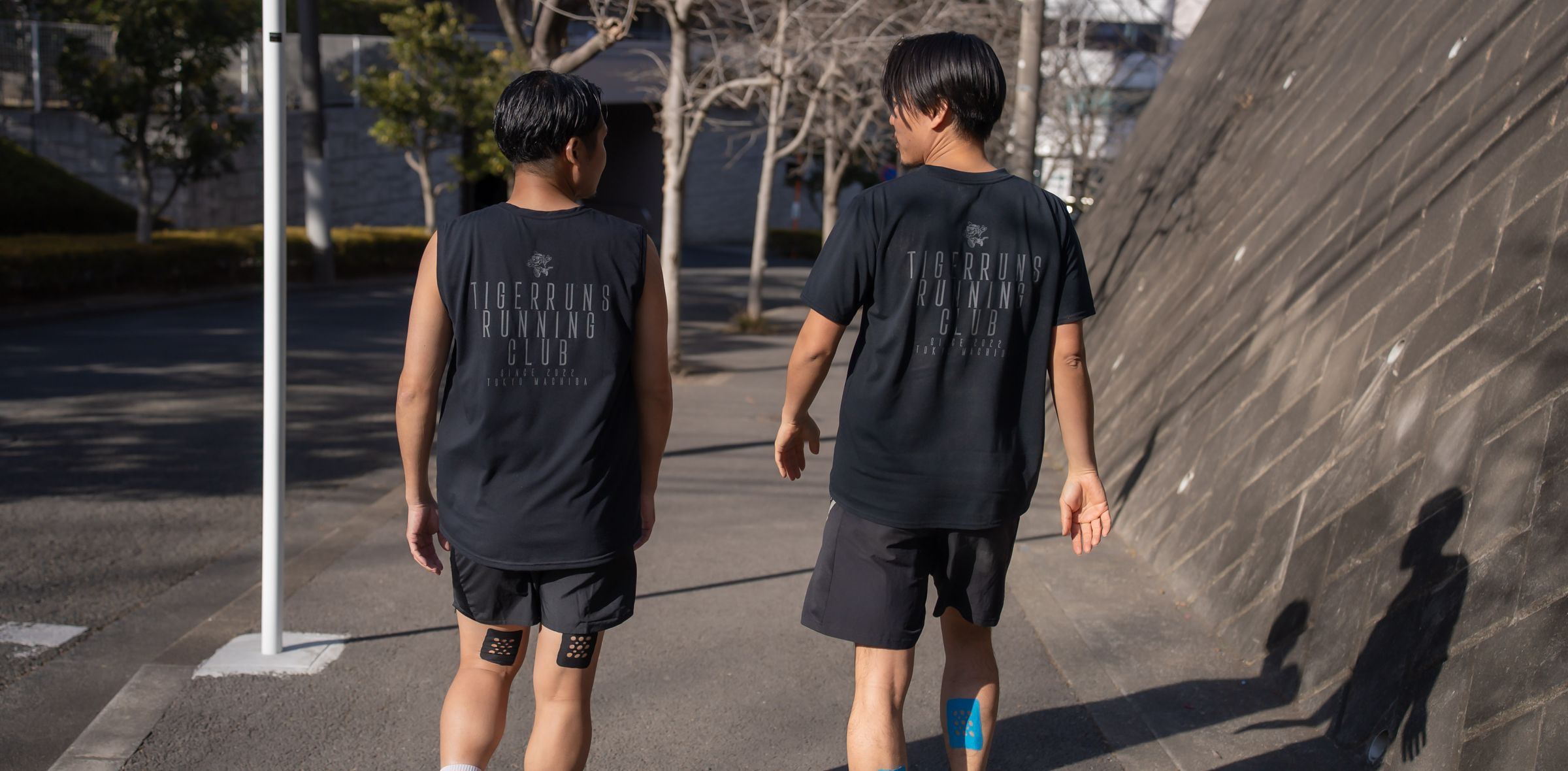 TIGERRUNS RUNNING CLUB のチームウェアを着て並んで走る後ろ姿